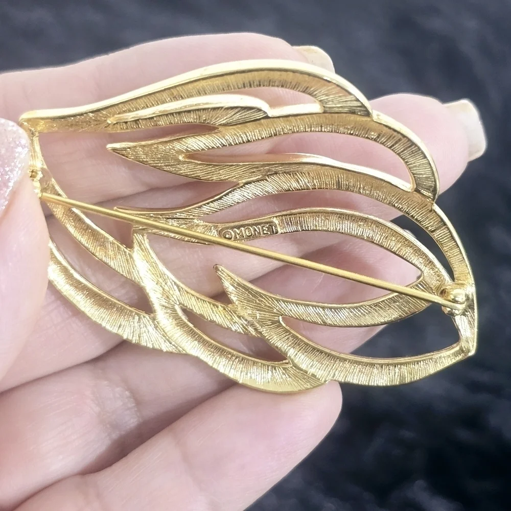 Monet Jewelry Two gold-tone leaf and penguin brooches